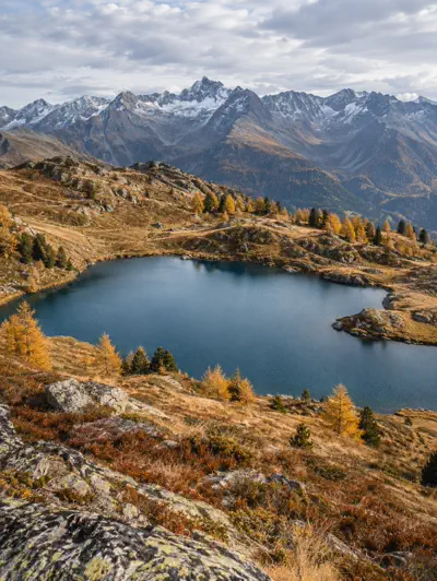 Türkiser Bergsee mit herbstlichen Bäumen